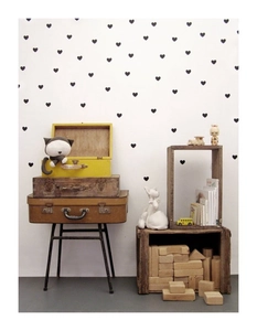 Black heart wall stickers in a cozy nursery setting with vintage luggage and plush toys
