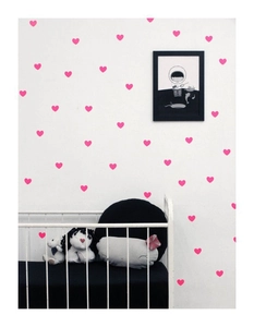 Detailed view of pink heart wall stickers arranged in a pattern on a nursery wall