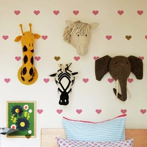 Detail of plush animal head wall decor with heart stickers in a cozy child bedroom