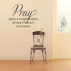 Detailed view of black Pray About Everything quote wall sticker in a bedroom setting