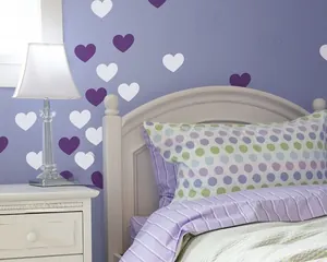 Detailed view of DIY heart wall stickers in purple and white on a bedroom wall