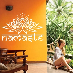 Detailweergave van een witte lotus yoga muursticker met namaste tekst op oranje muur