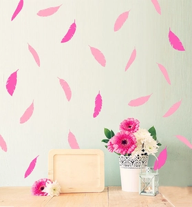 Detail of pink feather wall decals in a warm home setting with floral decor