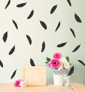 Detail of elegant black feather vinyl wall decals on a minimalist light green wall