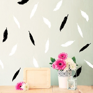 Minimalist feather wall decals for kids room in black and white vinyl on mint green wall
