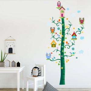 Detailed view of kids cartoon height growth chart with owl and tree on a white wall