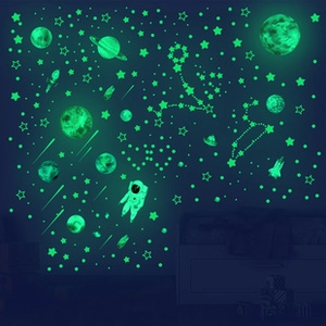 Glow in the dark wall decals showing glowing astronauts and planets in kids bedroom
