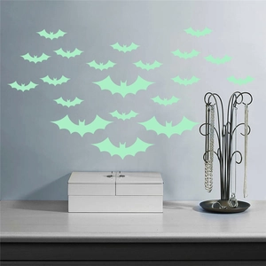 Detailed view of luminous bat wall stickers in various sizes on a minimalist grey wall background