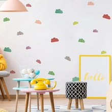 Close-up of minimalist colorful cloud wall decals arranged on a bedroom wall surface