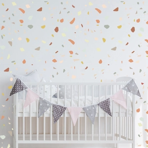 Detail of multi-color terrazzo wall stickers in a cozy minimalist nursery room setting