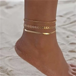 Close-up of triple layered gold layered anklet set featuring wheat and snake chain designs