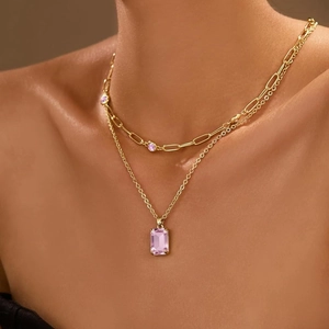 Layered gold necklace featuring a paperclip chain and purple crystal pendant for women