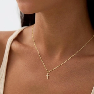 Elegante collana a croce dorata da donna con cristalli lucidi su una catena a fune