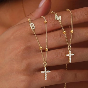 Goldene Edelstahlkette mit mikro-gepflastertem Kreuz und Kristall-Buchstaben-Anhänger