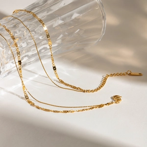 Three-layer stainless steel necklace with 18K gold plating featuring mixed twist and flat chains