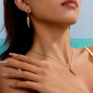 Golden fish pendant necklace and earrings set for women featuring ocean beach style design