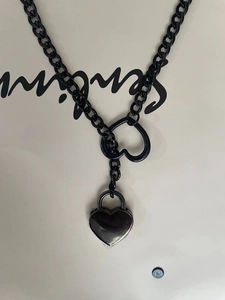Detailansicht der dunklen Punk-Cuban-Y-Kette mit schwarzem Herzschloss-Anhänger und Gliedern