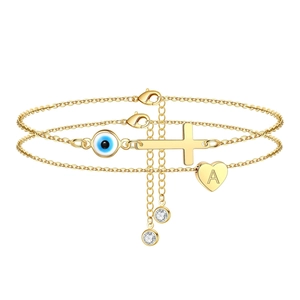 Cavigliera doppia dorata con occhio di Allah, croce e cuore su sfondo bianco pulito