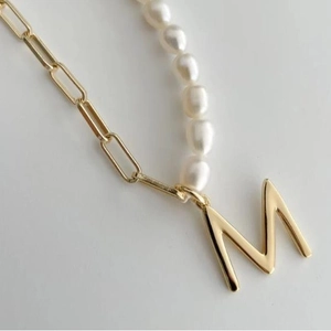 Asymmetric gold paperclip chain and white pearl necklace with large letter M pendant