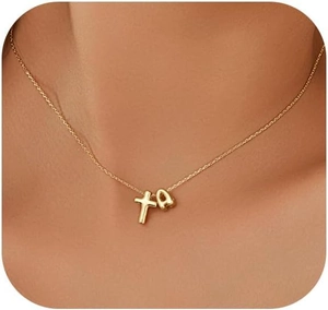 Close-up of gold chain necklace featuring cross pendant and letter 'a' on a model