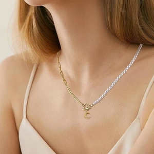 Asymmetric pearl and gold paperclip chain necklace with a crescent moon pendant and OT clasp
