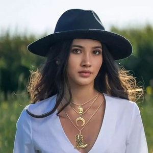 Collana dorata a tre strati con pendenti a stivale cowboy, luna e moneta su una modella