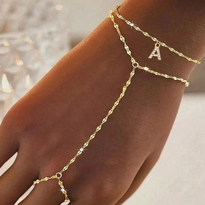 Detailaufnahme des goldenen Ring-Armbands mit A-Anhänger und funkelnden Zirkonen