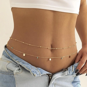 Gold double-layered waist chain with round sequins and blue beads on denim jeans