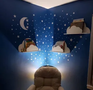 Close-up of white cloud-shaped wall shelves installed on a dark blue star-patterned wall