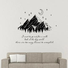 Sticker mural inspirant avec montagnes et croissant de lune au-dessus d'un canapé gris