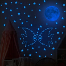 Stickers muraux phosphorescents lune, étoiles et papillon bleus dans une chambre d'enfant