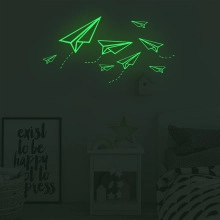Luminous paper airplane wall stickers showing green glow effect in dark bedroom