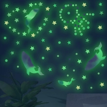 Glow in the dark whale and star wall stickers showing luminous green effect in kids room