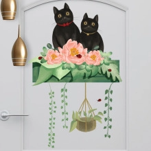 Glow-in-the-dark cat wall stickers with pink peony flowers and green plants on door