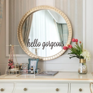 Gros plan d'un miroir mural doré avec lettrage artistique hello gorgeous et relief
