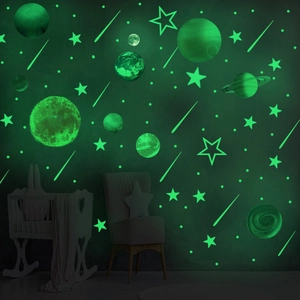 Luminous wall stickers set with glowing planets and stars in a dark nursery room