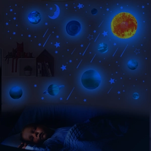 Luminous wall stickers set showing glowing planets and stars in a dark nursery bedroom