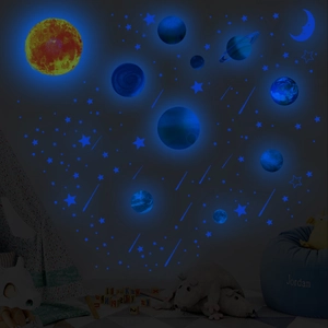 Luminous solar system wall stickers glowing with blue and orange light in dark room