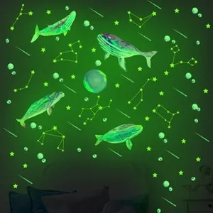 Luminous wall stickers featuring whales and constellations glowing in emerald green neon