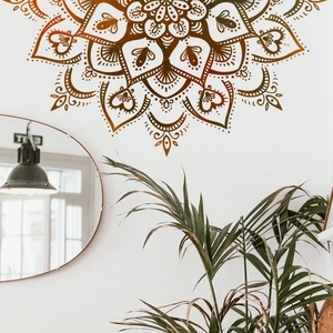 Makrodetail eines braunen Mandala Wandtattoos in einem hellen Wohnzimmer im Boho-Stil