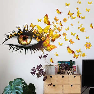 Détail d'un sticker mural artistique avec œil géant et papillons orange éclatants