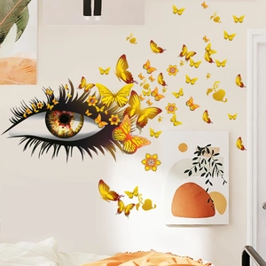 Détail d'un sticker mural créatif avec un œil réaliste et des papillons jaunes et fleurs d'or