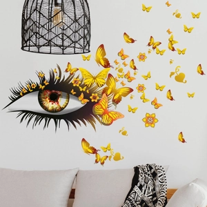 Détail de l'autocollant mural œil réaliste avec papillons orange sur mur de salon
