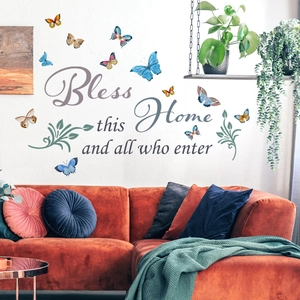 Sticker mural Bless this Home avec papillons 3D colorés sur canapé orange