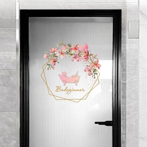Détail du sticker mural salle de bain avec fleurs roses et texte Badezimmer sur verre