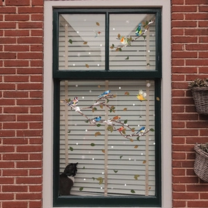 Detail of static window cling stickers with realistic birds on branches and snowflakes