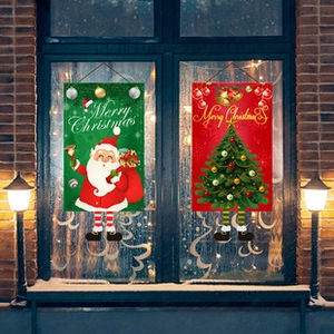 Detail of Christmas garden flags with Santa and tree motifs for festive wall decoration