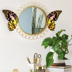 Close-up of decorative gold sunflower wall mirror with realistic butterfly wings on both sides