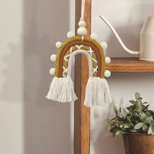 Detail of bohemian woven cotton rainbow with tassels and wooden beads for wall decor