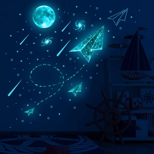 Glow-in-the-dark space wall decals featuring moon, stars and origami planes in cyan blue